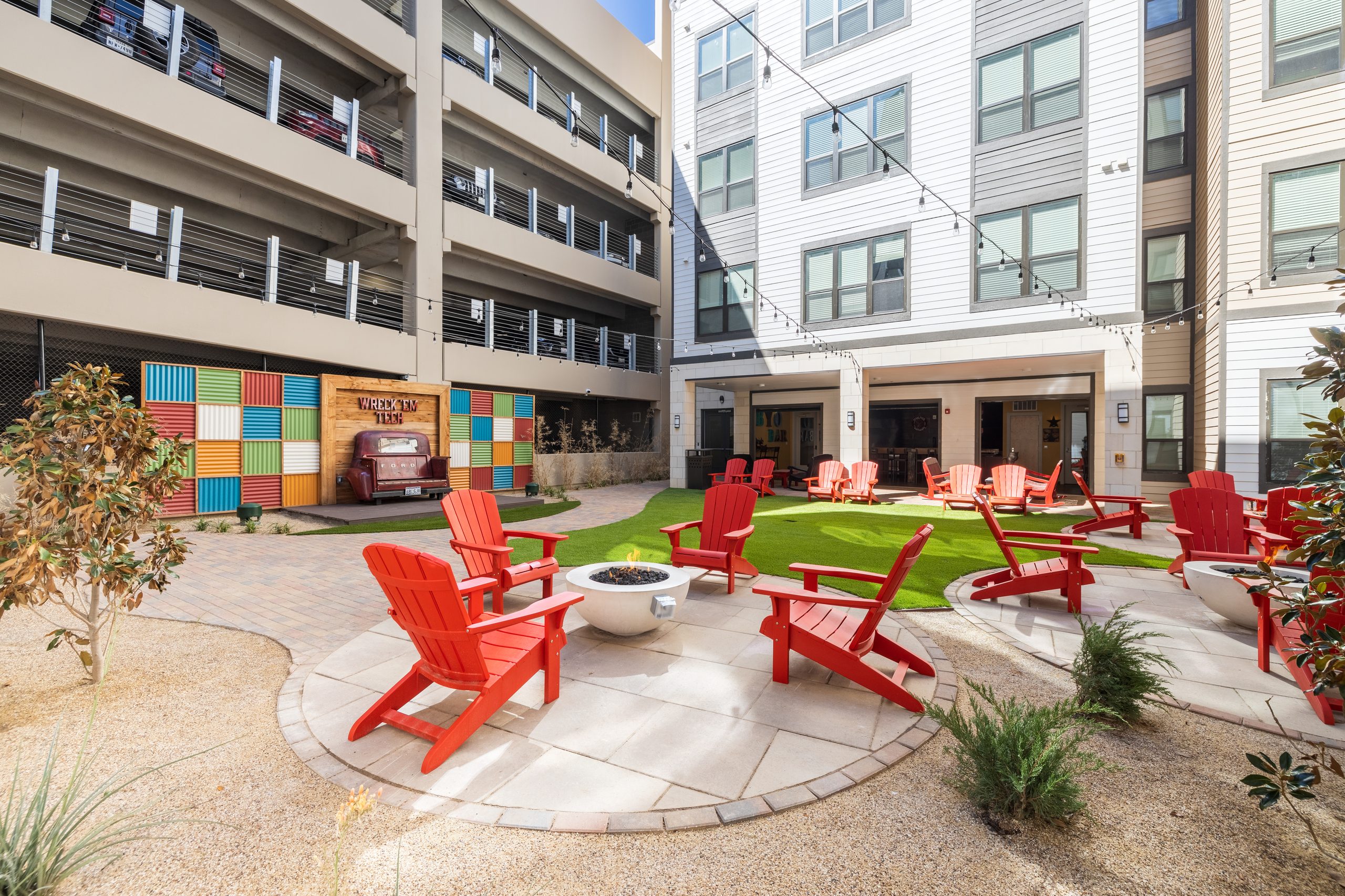 Courtyard fire pit surrounded by Adirondack chairs