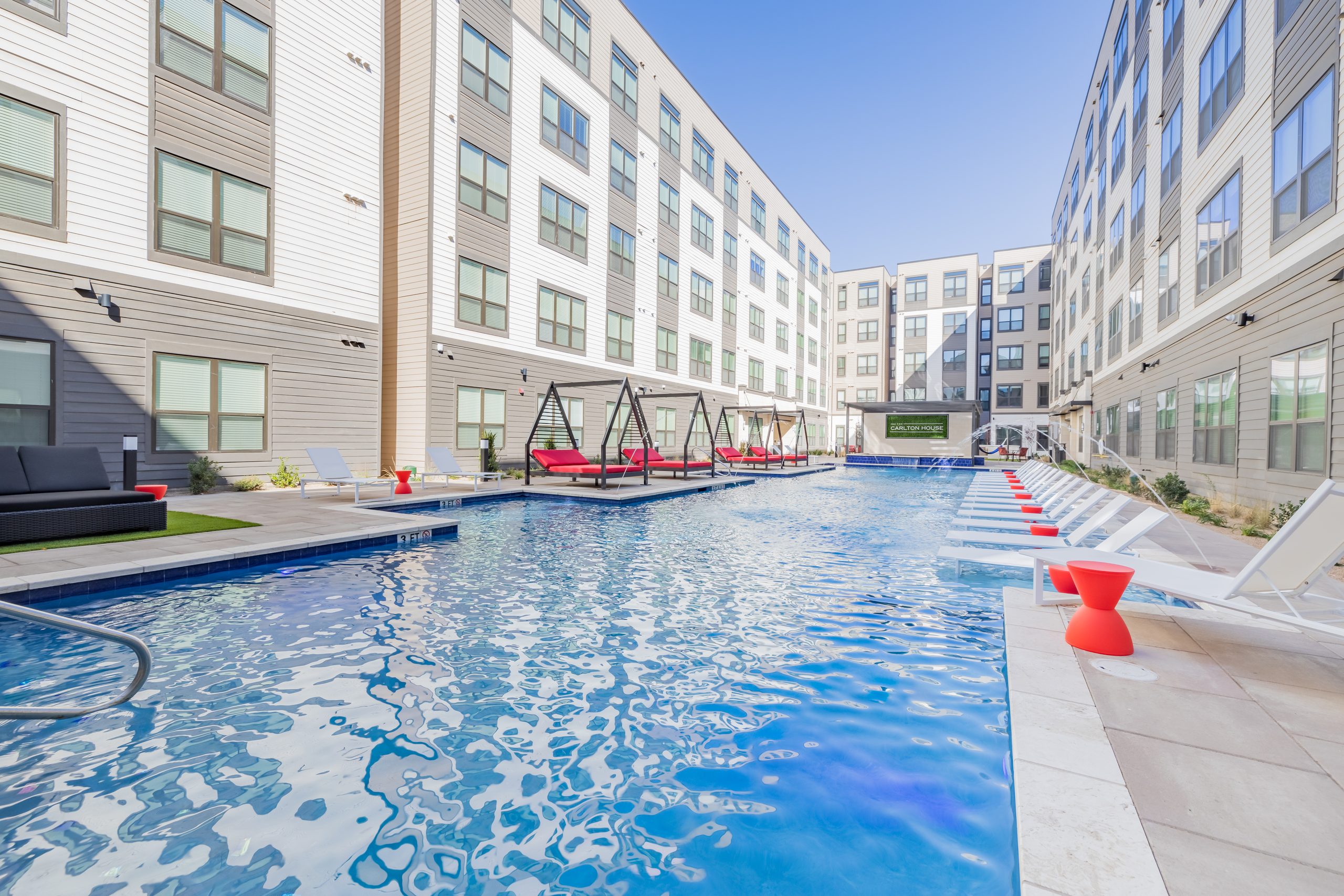 Swimming pool and sun deck framed by the building courtyard